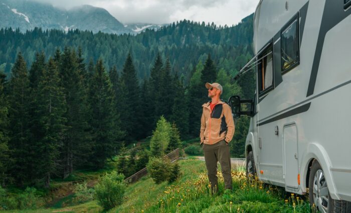 Viajero junto a una camper en la montaña